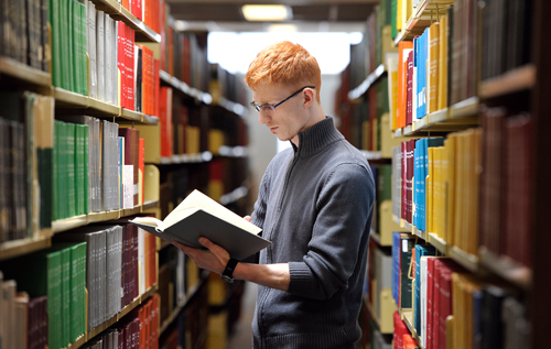 This is an image of a student reading a textbook in the library. Click to find and buy/rent your textbooks