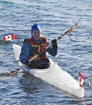 Dr. Paul Berger paddling an kayak made of ice