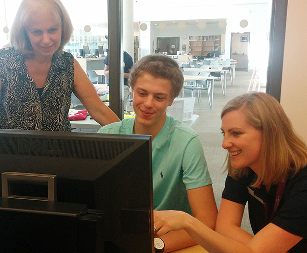 New Lakehead student, Eric Hill of Toronto, registers for courses with the help of Student Advisor Jackie Bean, as his mother looks on. 