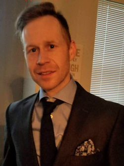 Headshot of EPID Trainee Matthew Garrod looking dashing in his suit
