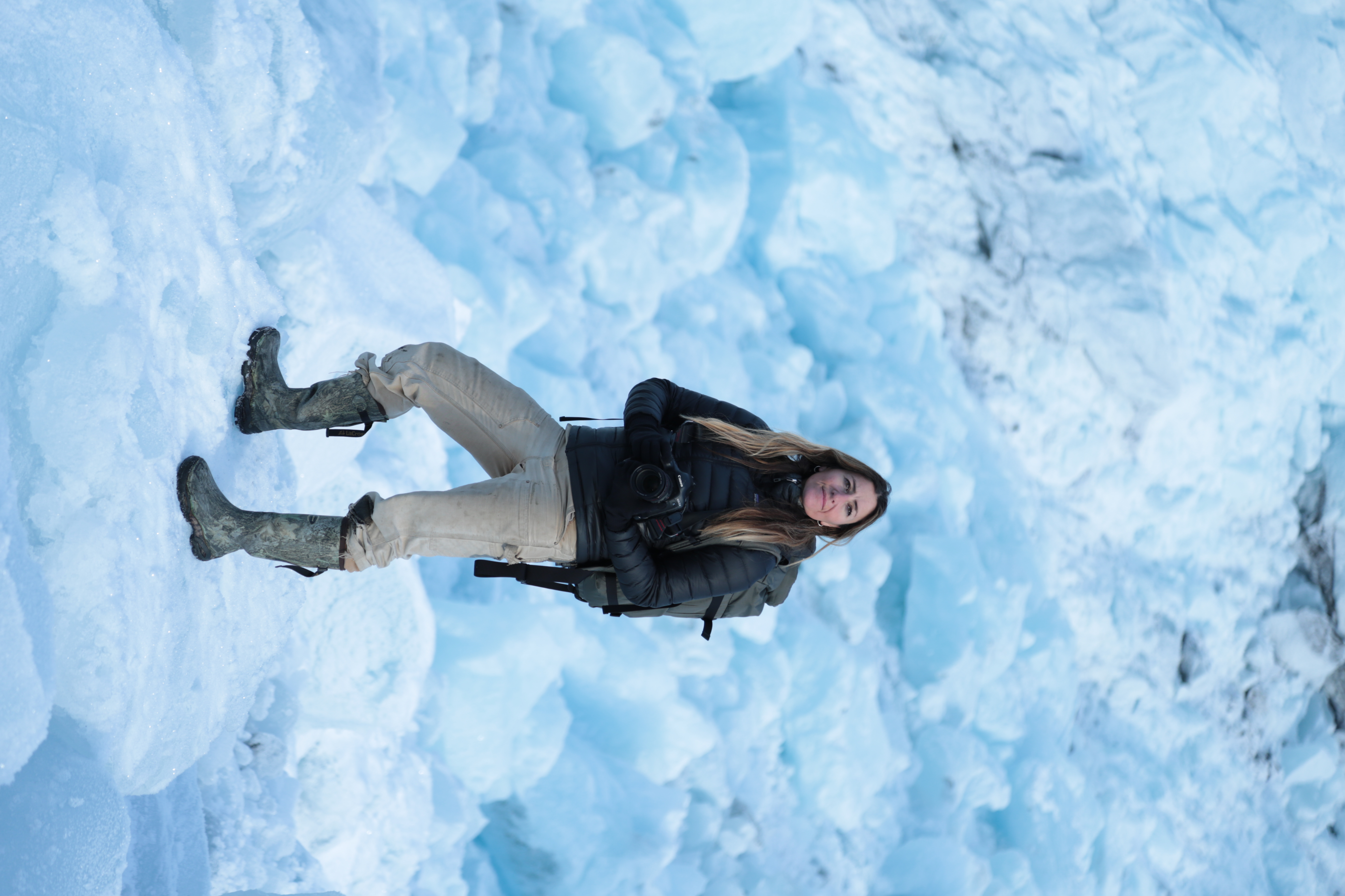 Jody standing outside in Alaska holding a camera