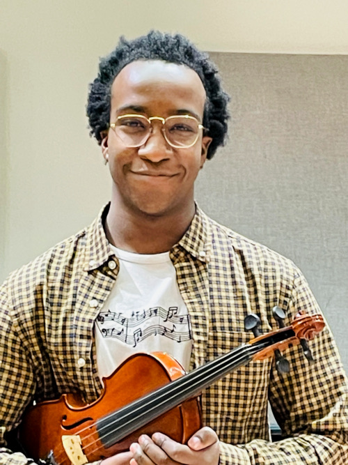 Lakehead music student Amani Sloley smiles while holding a viola