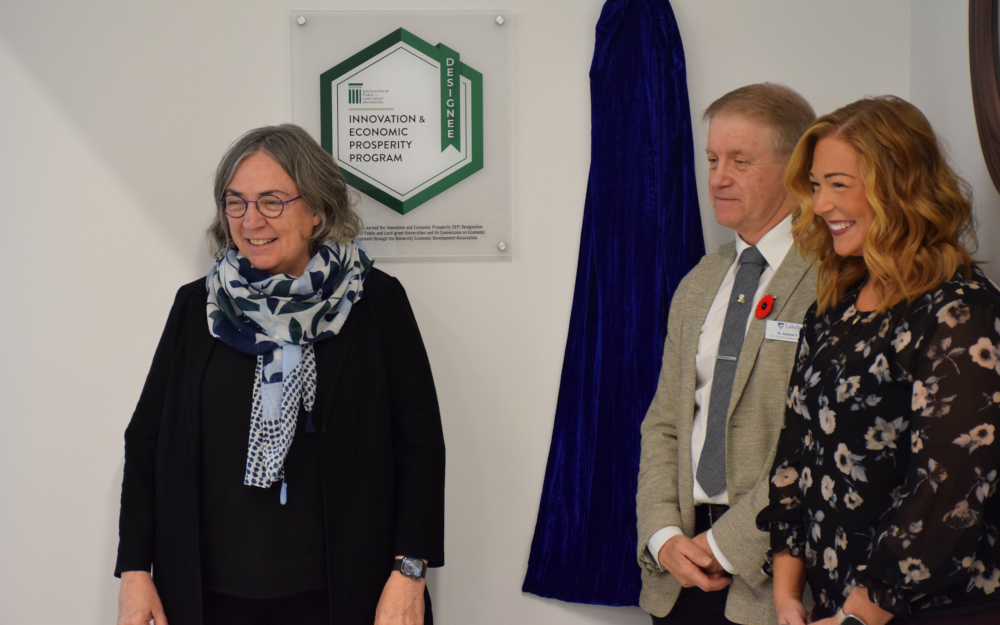 Dr. Gillian Siddall, Dr. Andrew P. Dean, and Ellen MacKay stand by the IEP plaque