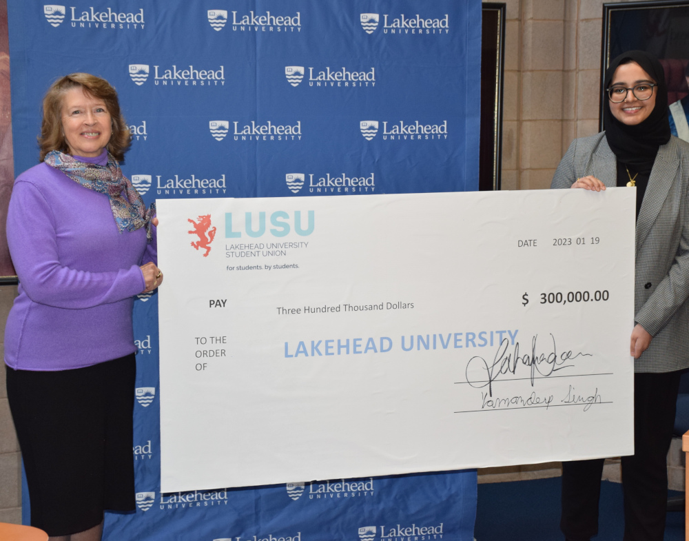 LUSU president presents a $300,000 cheque dated January 19, 2023 to Lakehead President Moira McPherson
