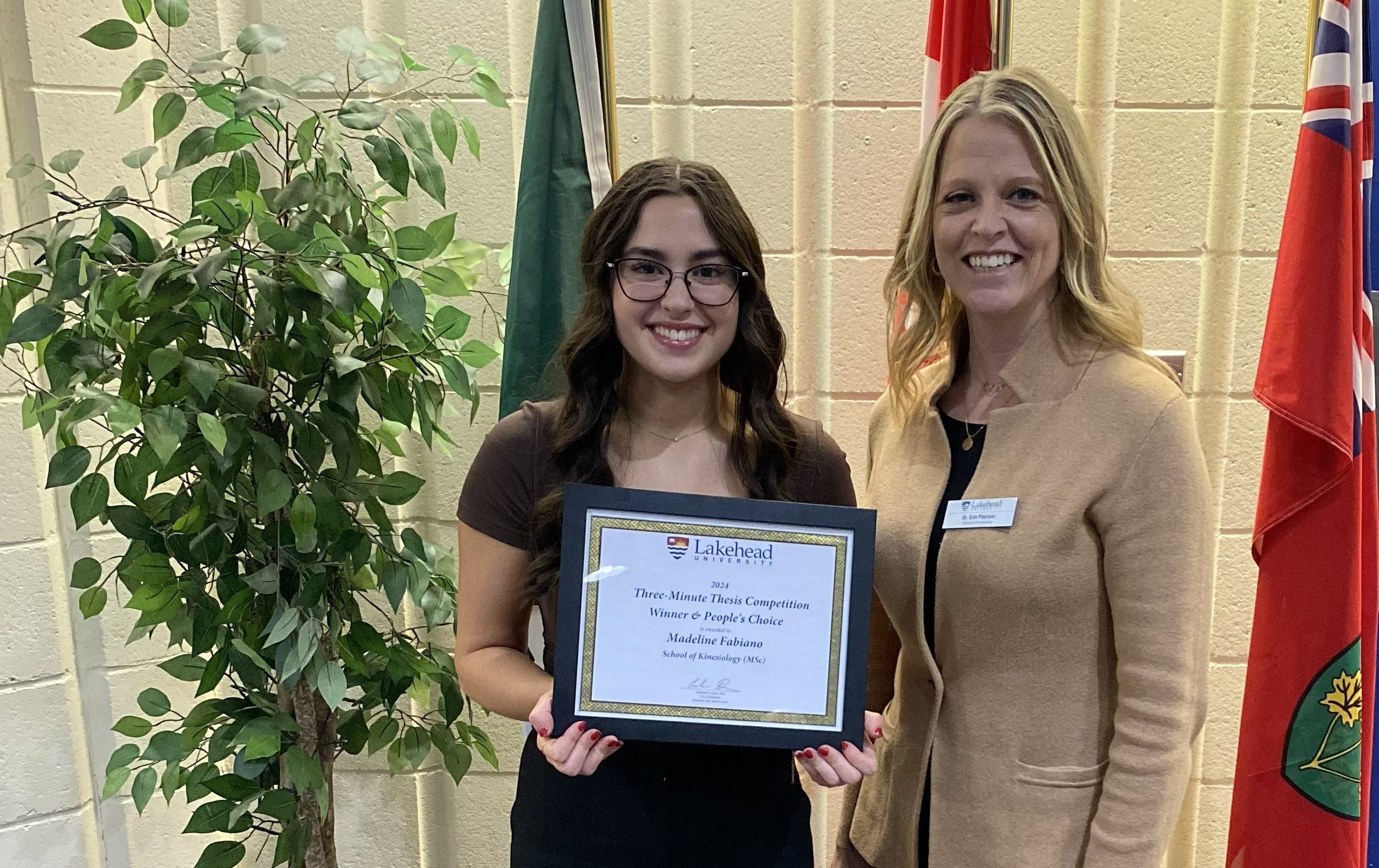 Madeline Fabiano & Dr. Erin Pearson Madeline Fabiano, standing beside Dr. Erin Pearon, holds up a framed certificate with the words 2024 Three-Minute Thesis Competition Winner & People's Choice is presented to Madeline Fabiano School of Kinesiology (MSc)