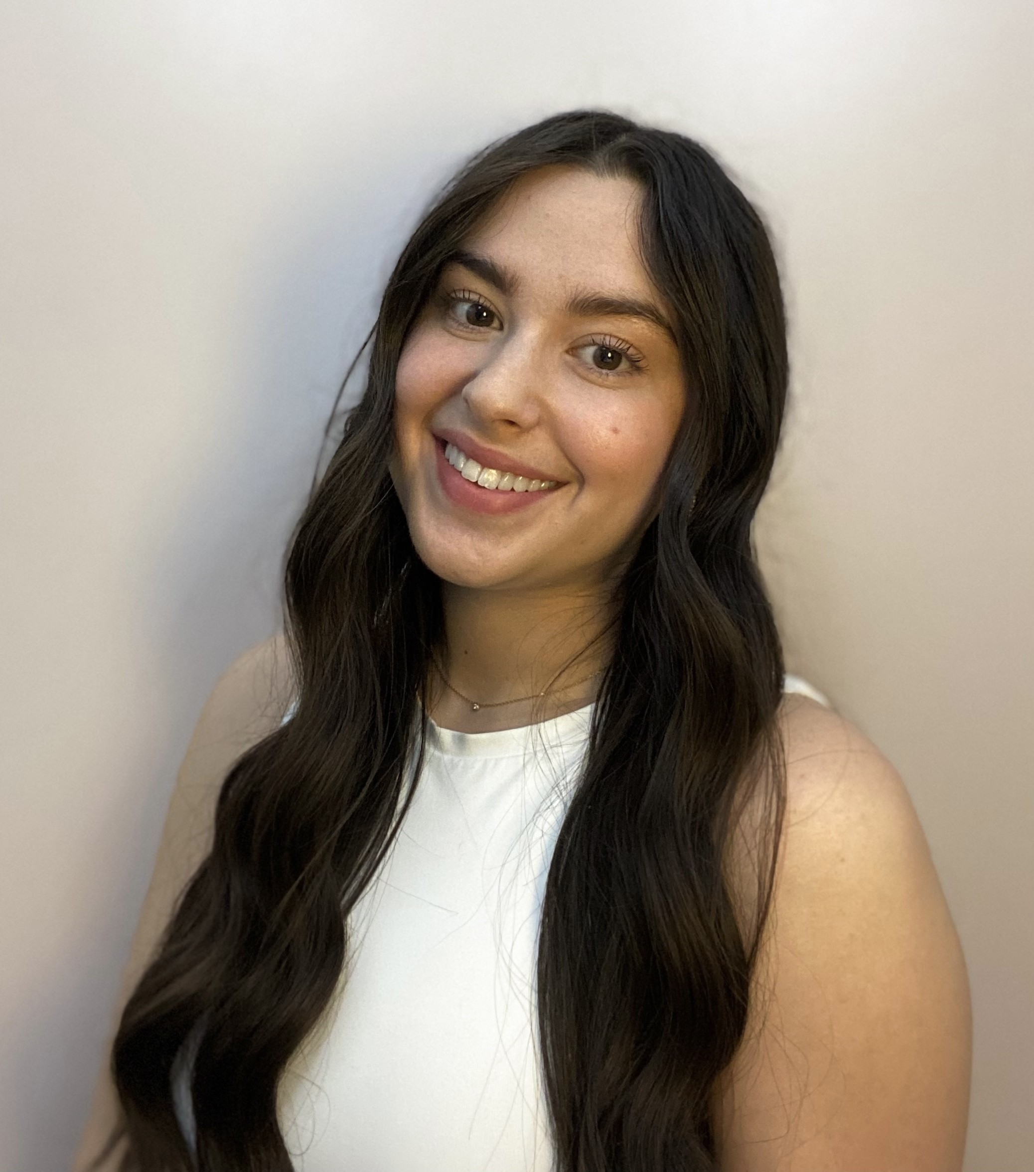 Madeline Fabiano Headshot A head-and-shoulders image of Madeline Fabiano wearing a white sleeveless top and a small gold chain