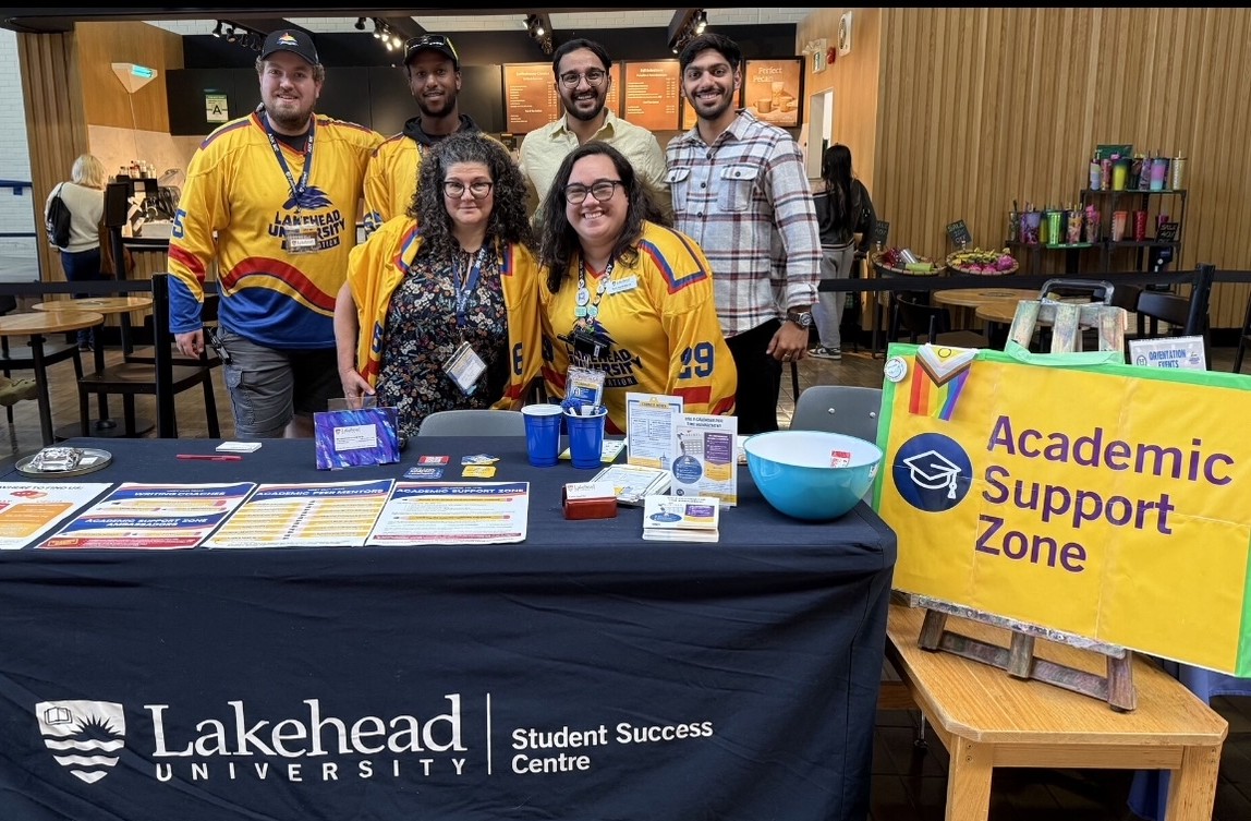 Brandon Rehfuhs and Student Success Centre staff stand together at an information table