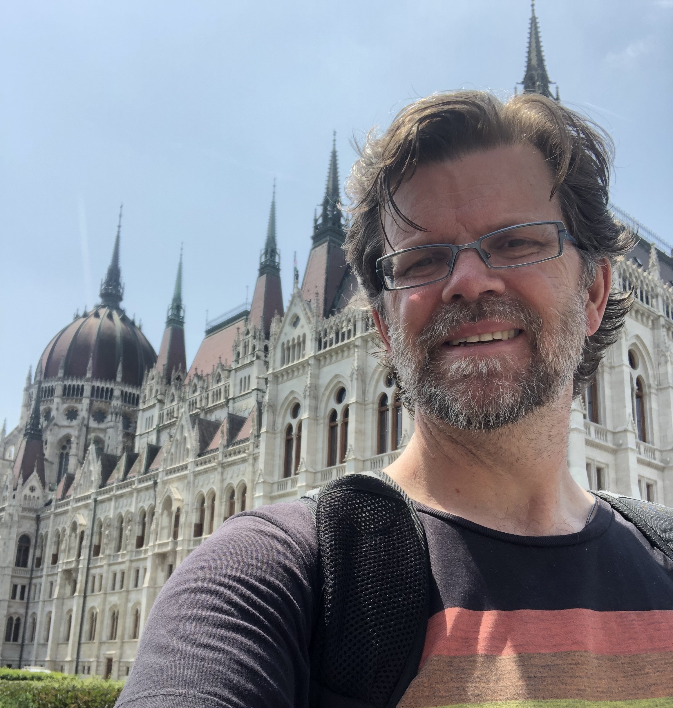 Dr. Steve Jobbitt stands outside of Hungary's gothic-style parliament building on a sunny day