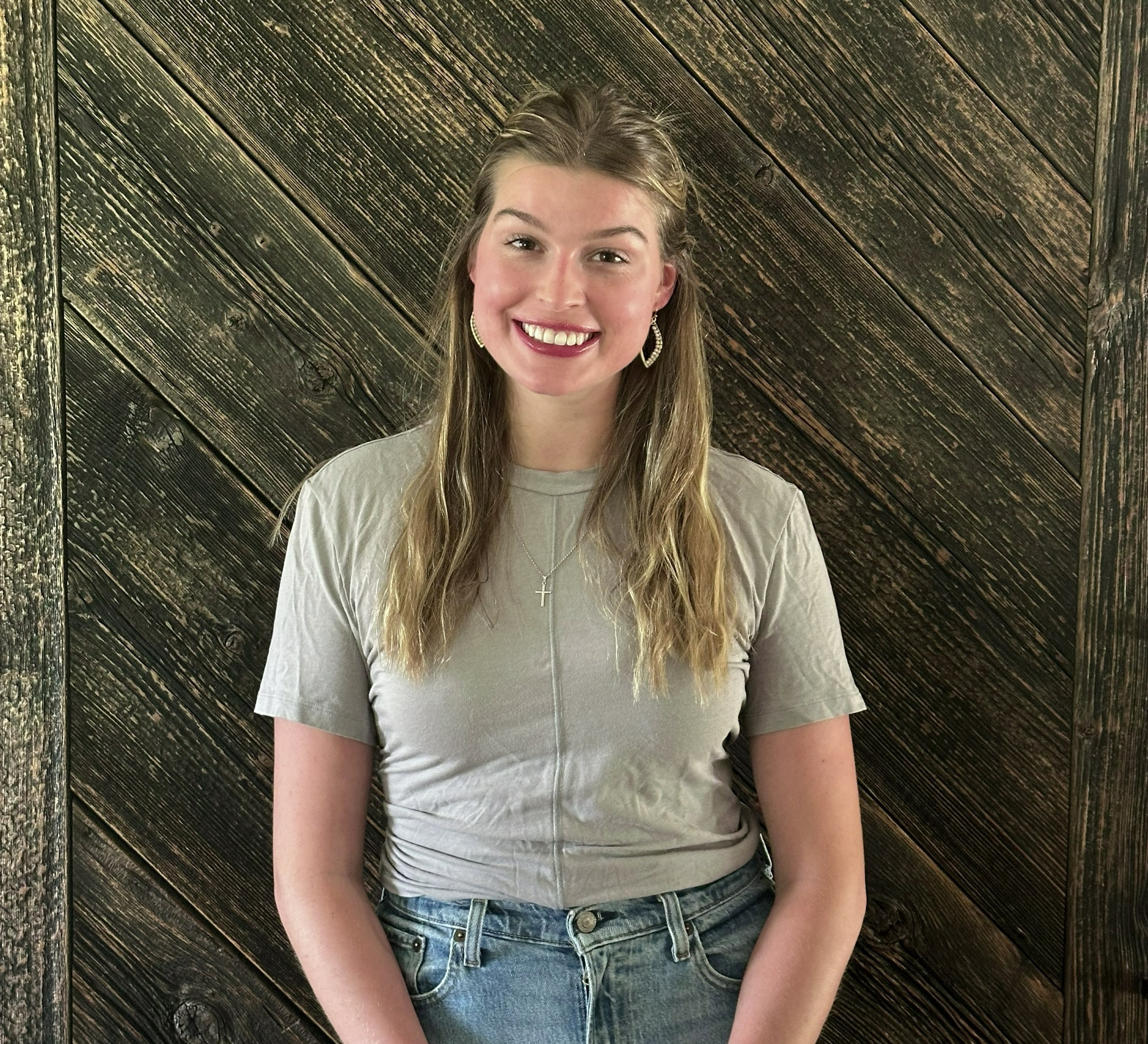Hope Grootenboer stands in front of wooden plank wall