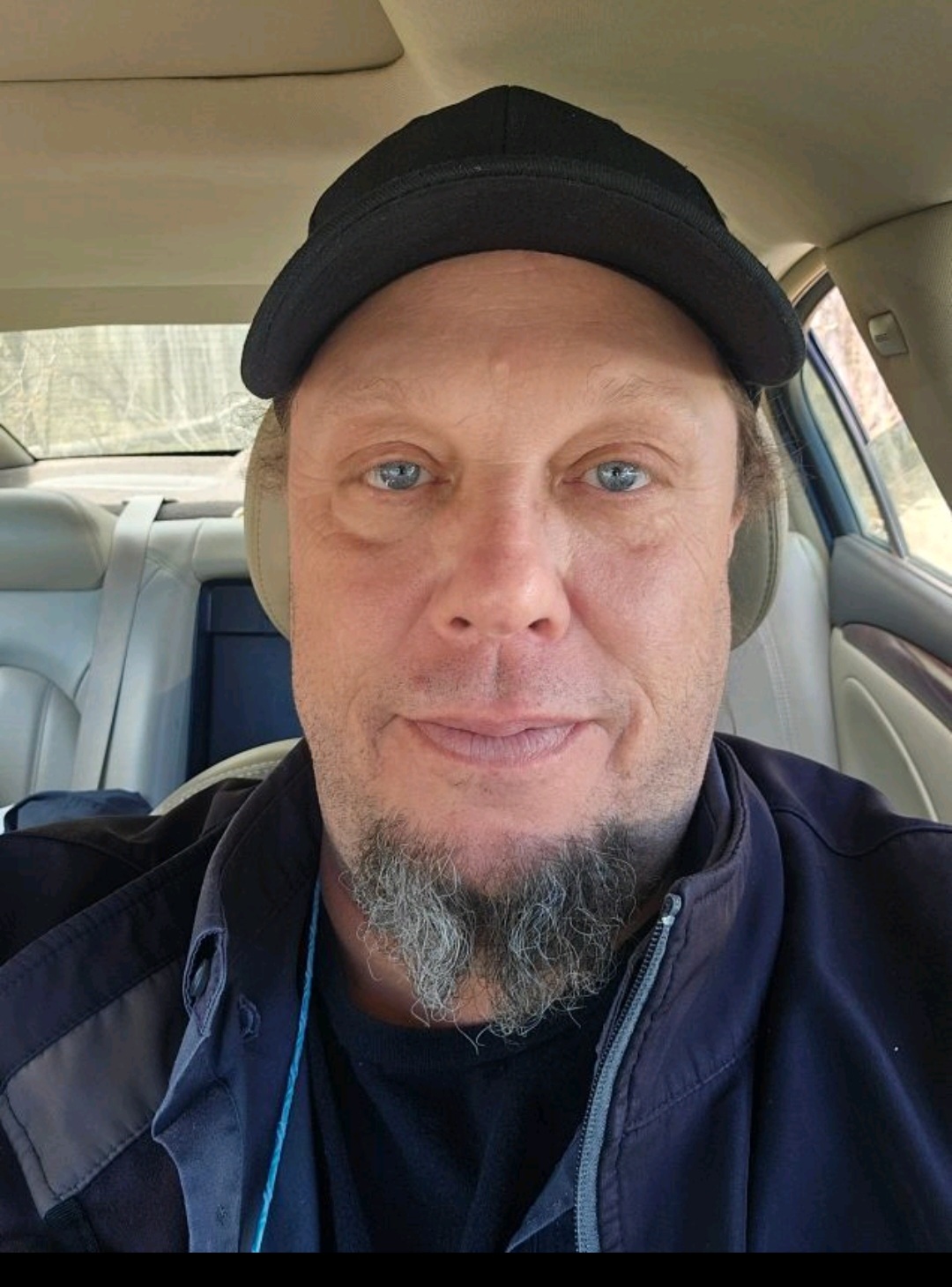 John Mulloy John Mulloy, wearing a black cap, sits in the front seat of a car