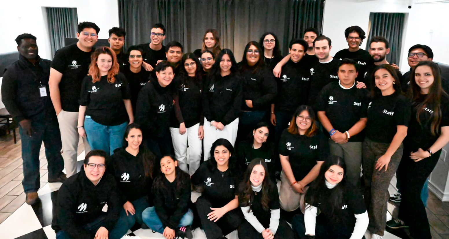 Group GMNYC2026 Photo A large group of young people wearing black t-shirts smiles for the camera