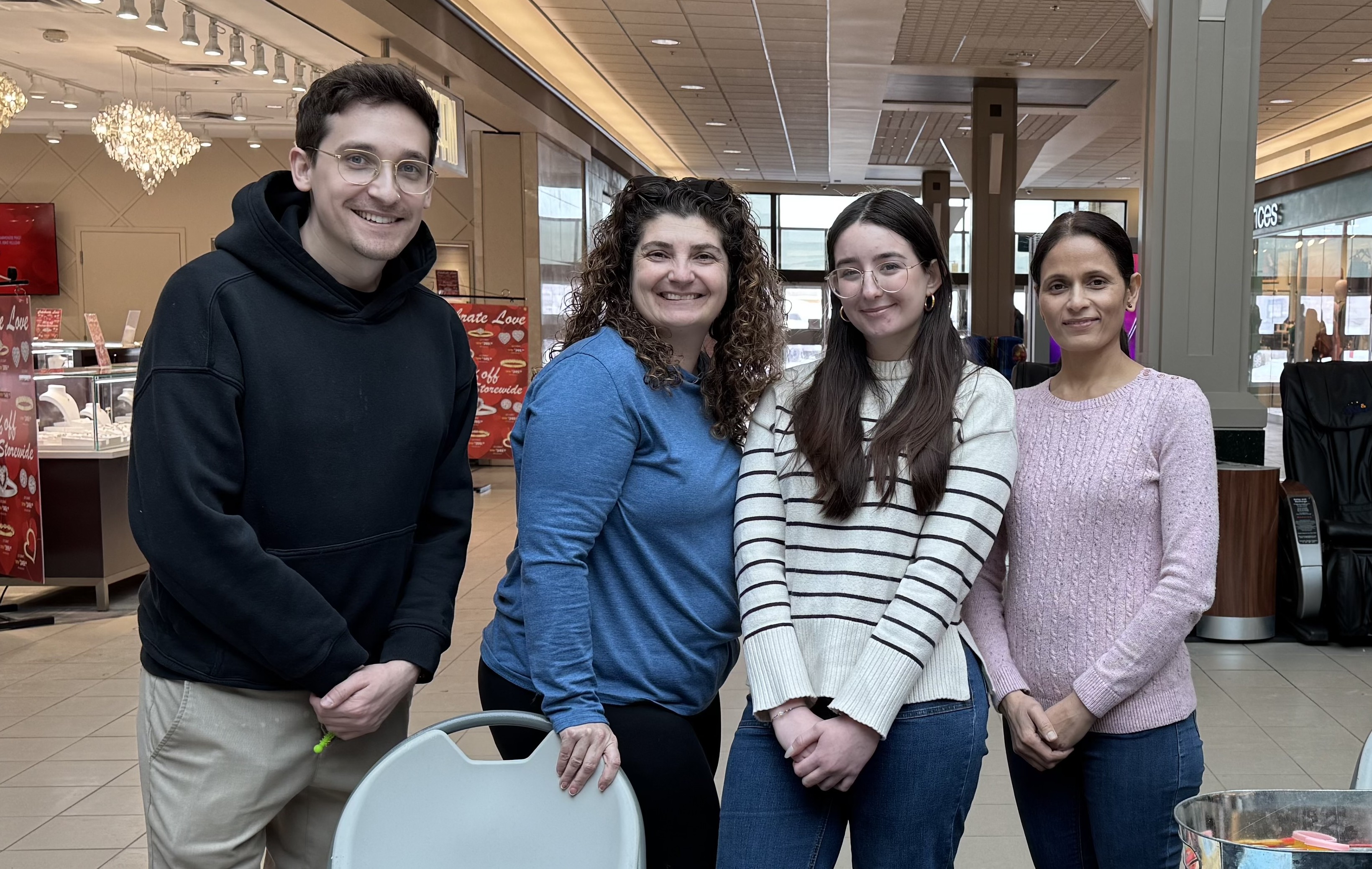 Students Steven Kearney, Kris Carlson, Tessa Pasqualino, and Shanta Paudel Khatiwada stand beside each other in Intercity Mall