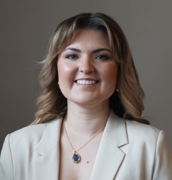 A head-and-shoulders photo of Taylor Munro wearing a cream blazer and a pendant