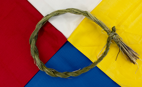 A 4 colour flag with intertwined sage shaped into a wheel at the center of it