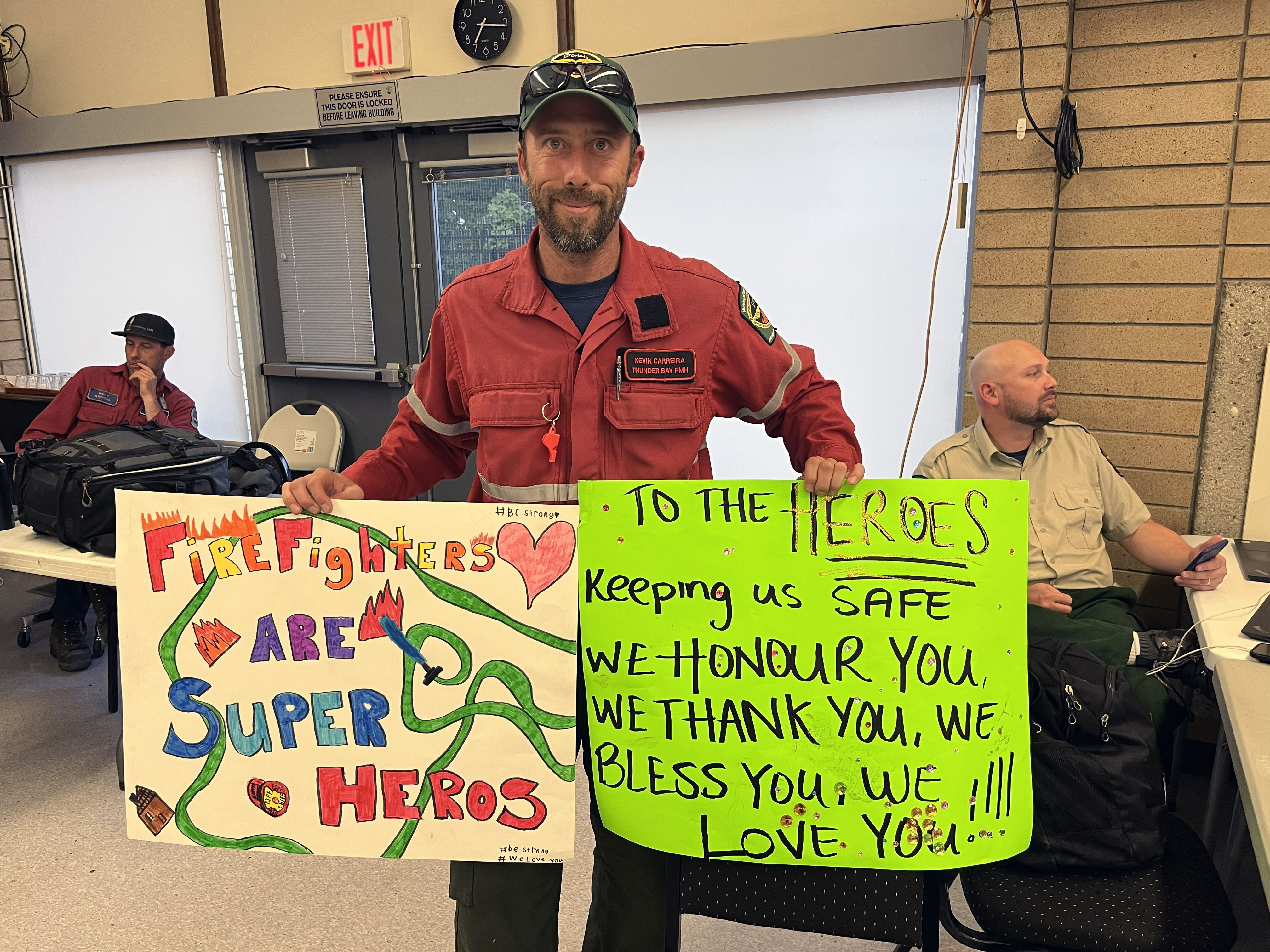 Kevin holding signs from the public while on a fire in Kelowna