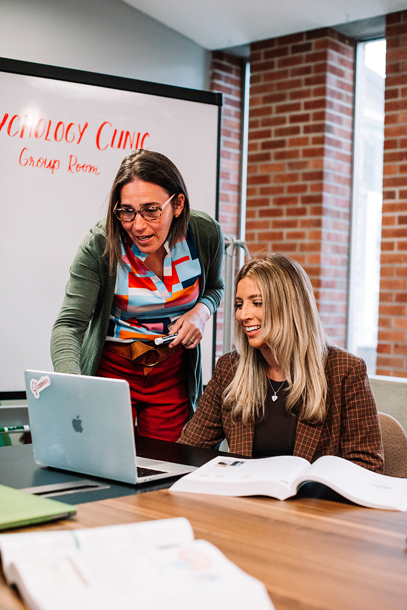 Two staff members navigating a computer