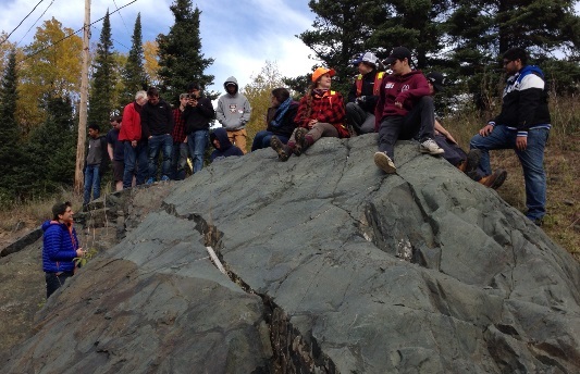 A group of people on top of a boulder 