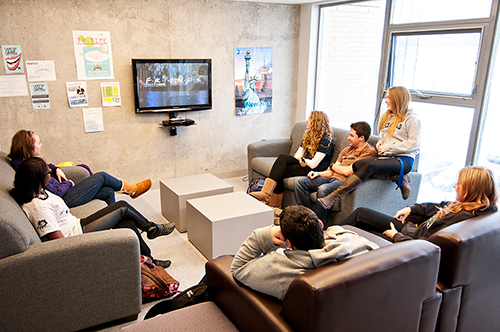 Students relaxing in a common area watching tv